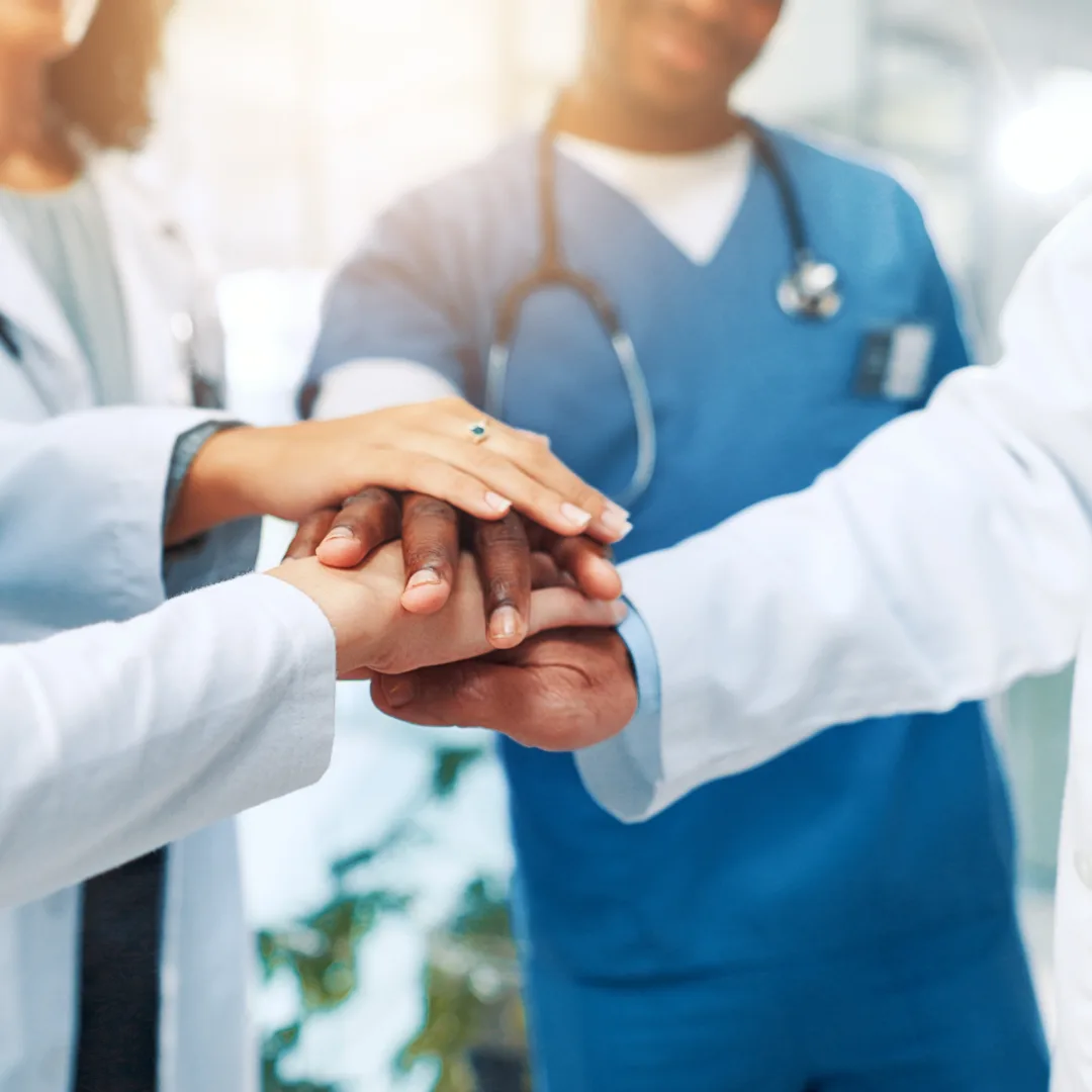 Clinicians and research staff joining hands